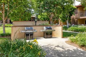 Azusa apartment for rent - Two BBQ grills are situated on a concrete platform in a grassy area.
