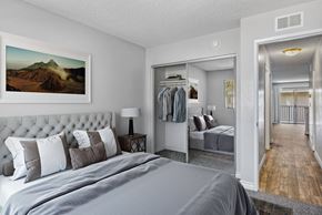 Spring Valley apartment for rent - A bedroom with a large bed and a painting of a mountain on the wall.