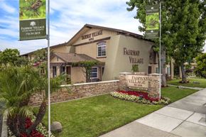Anaheim apartment for rent - The front of Fairway Village with a sign and flowers.