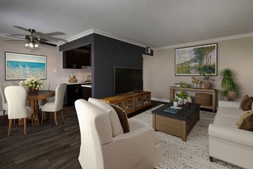 Anaheim apartment for rent - A living room with a white couch, a wooden coffee table, and a painting on the wall.