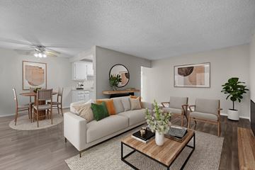 Garden Grove apartment for rent - A living room with a white couch, wooden coffee table, and a dining table with chairs.