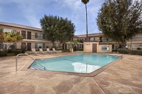 Garden Grove apartment for rent - A pool surrounded by a patio and trees.