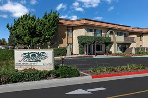 Oxnard apartment for rent - A building with a sign that says Los Arbolitos in front of it.