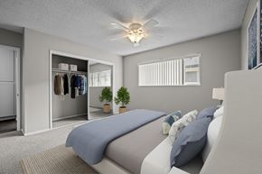 Huntington Beach apartment for rent - A bedroom with a bed, pillows, a ceiling fan, and a closet.