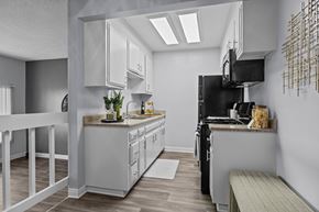 Santee apartment for rent - A modern kitchen with white cabinets and a black refrigerator.