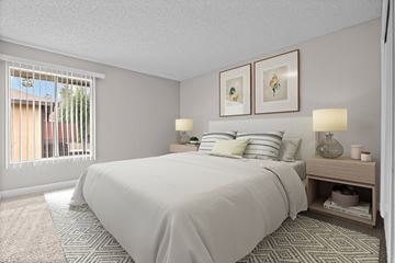 Riverside apartment for rent - A bedroom with a large bed and a window with blinds.