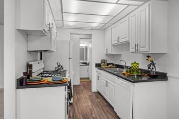 Upland apartment for rent - A kitchen with white cabinets and a black countertop.