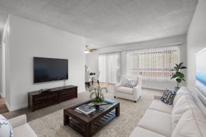 Upland apartment for rent - A living room with a white couch, a wooden coffee table, and a flat-screen TV.