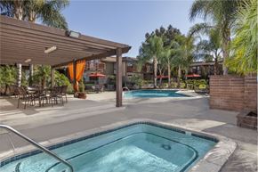 Riverside apartment for rent - A pool and jacuzzi with a patio with chairs and a table.