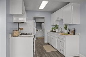 Oceanside apartment for rent - A white kitchen with a stove, oven, and cabinets.
