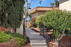 Oceanside apartment for rent - A residential area with a house, trees, and a small garden.