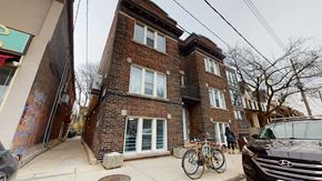 Toronto apartment for rent - A brown brick building with a bicycle leaning against it.