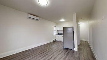 Toronto apartment for rent - A kitchen area with a refrigerator and a television.