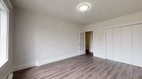 Toronto apartment for rent - A room with wooden flooring and white walls.