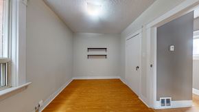 Toronto apartment for rent - A room with wooden floors and white walls.