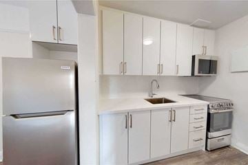 Toronto apartment for rent - A kitchen with white cabinets and a stainless steel refrigerator.