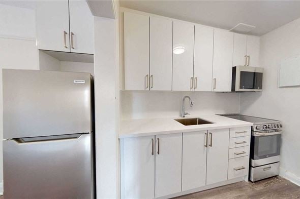 Toronto apartment for rent - A kitchen with white cabinets and a stainless steel refrigerator.