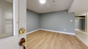 Toronto apartment for rent - A room with wooden flooring and a white door with a gold handle.
