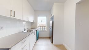 Toronto apartment for rent - A kitchen with white cabinets and a blue fridge.
