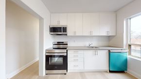 Toronto apartment for rent - A kitchen with white cabinets and a black oven.