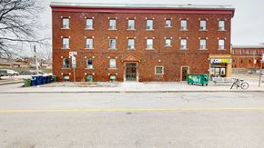 Toronto apartment for rent - A red brick building with a yellow sign on the right side.