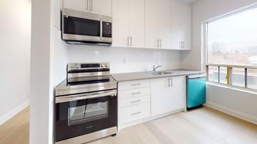 Toronto apartment for rent - A modern kitchen with white cabinets and a stainless steel oven.