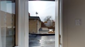 Toronto apartment for rent - A view from inside a room looking out through a glass door to a residential street.