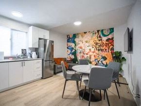 Toronto apartment for rent - A kitchen with a table and chairs in front of a colorful wallpaper.