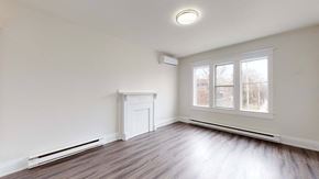 Toronto apartment for rent - A room with a window, a radiator, and a white fireplace.