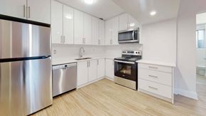 Toronto apartment for rent - A modern kitchen with stainless steel appliances and white cabinets.