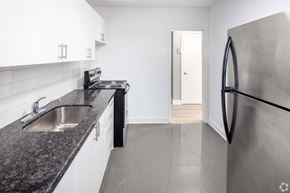 Toronto apartment for rent - A kitchen with a black granite countertop and a stainless steel refrigerator.