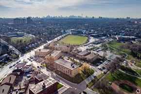 Toronto apartment for rent - A large building with a green field in front of it.