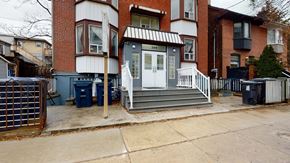 Toronto apartment for rent - A house with a white door and a black trash can in front of it.