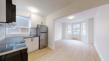 Toronto apartment for rent - A kitchen with a refrigerator, cabinets, and a stove top oven.