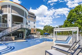 Mooresville apartment for rent - A large swimming pool is surrounded by a white fence and chairs.