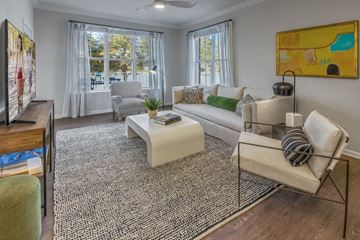 Mooresville apartment for rent - A living room with a white couch, a coffee table, and a painting on the wall.
