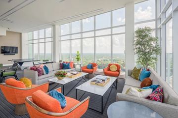 Durham apartment for rent - A living room with a grey couch, orange chairs and a coffee table.