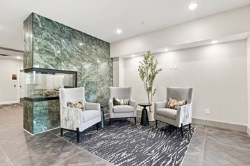 Mahtomedi apartment for rent - A living room with a green marble wall and white chairs.