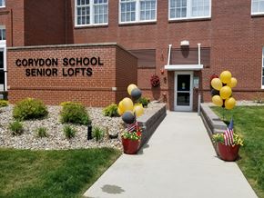 Corydon apartment for rent - the front entrance of cooper school senior lofts with balloons in front of the building