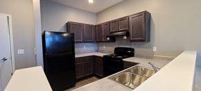 Vincennes apartment for rent - a kitchen with a black refrigerator and a sink