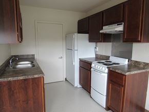 Evansville apartment for rent - a kitchen with white appliances and wooden cabinets