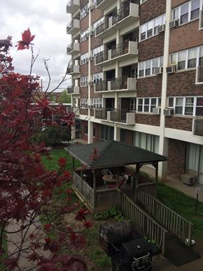 Evansville apartment for rent - an apartment building with a small porch and a red tree