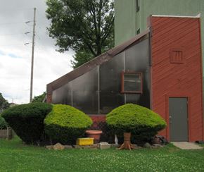 Evansville apartment for rent - the side of a house with a greenhouse and some bushes
