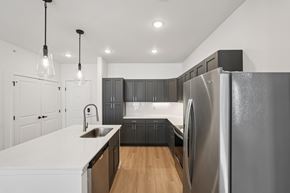 Fortville apartment for rent - A modern kitchen with a large refrigerator and wooden floors.