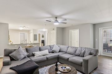 Spartanburg apartment for rent - A grey sectional sofa with a black throw pillow sits in a living room with a ceiling fan and a coffee table.