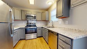 Fortville apartment for rent - A kitchen with a stainless steel refrigerator and wooden floors at Ridgeview Apartments, Fortville, Indiana