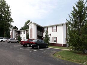 Fortville apartment for rent - A parking lot with cars and a building with a star on the front at Ridgeview Apartments, Fortville, IN, 46060