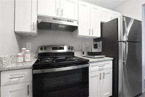 Lebanon apartment for rent - A black and white photo of a kitchen with a stove, oven, and refrigerator at Parkview of Lebanon Apartments, Lebanon, IN, 46052