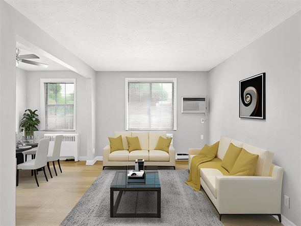 Kettering apartment for rent - A living room with a white couch and yellow pillows at Huntley Ridge Apartments, Kettering, Ohio