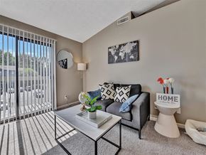 Milford apartment for rent - A living room with a grey couch, a coffee table, and a sign that says  at The Reserve at Grand Valley Apartments, Milford 46150